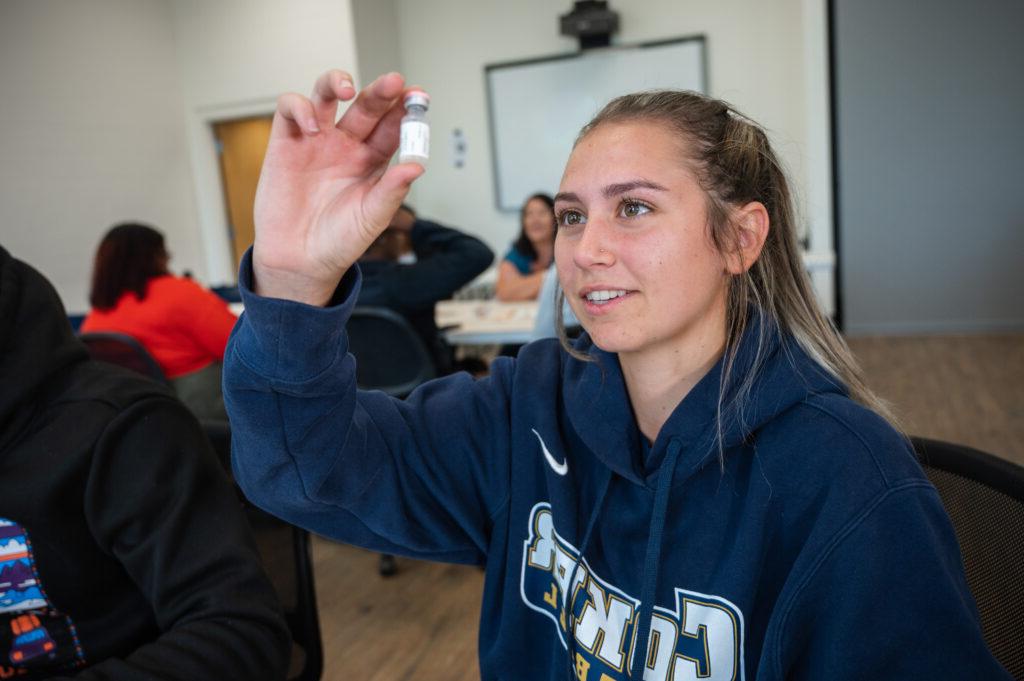 a student looks at a vial in class